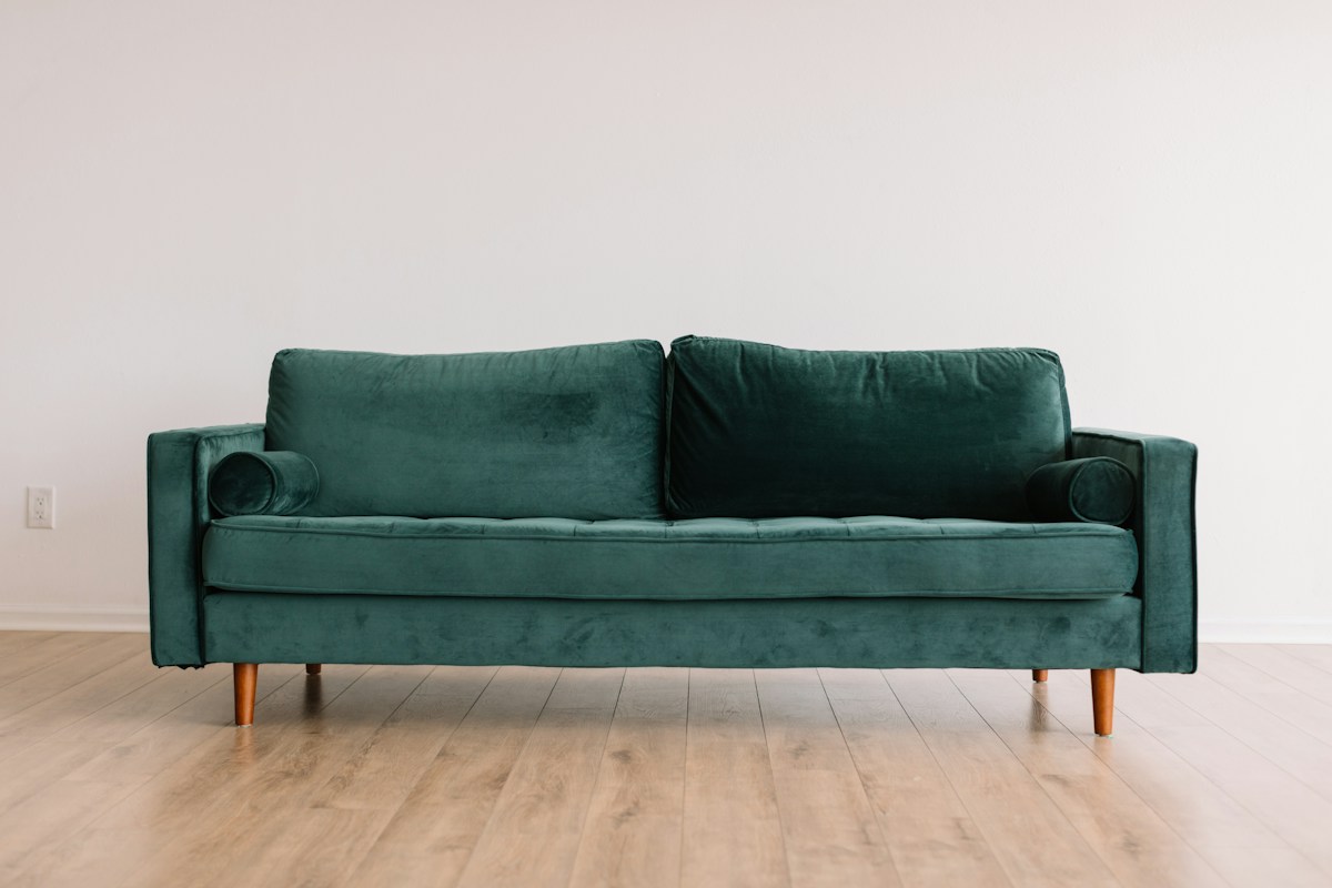 Elegantly upholstered emerald modern living room sofa with pillows